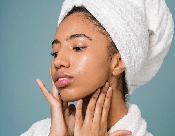 woman in robe touching face